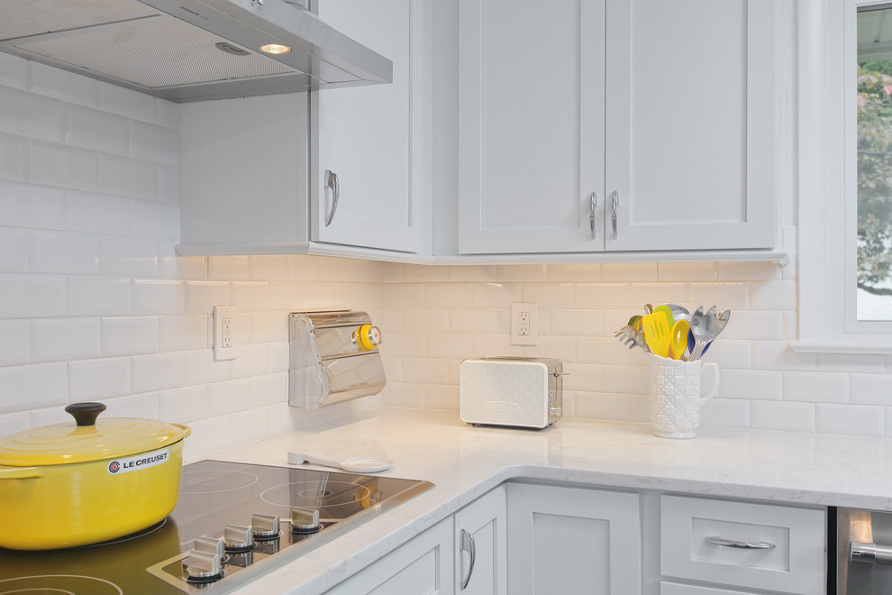 Foto de cocinas en L clásica renovada, de tamaño medio, abierta, con fregadero sobremueble, armarios estilo shaker, puertas de armario blancas, encimera de mármol, salpicadero blanco, salpicadero de azulejos tipo metro, electrodomésticos de acero inoxidable, suelo de pizarra y una isla