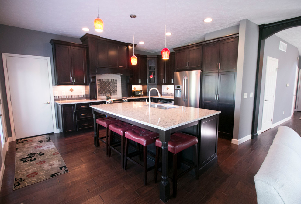 Inspiration for a large contemporary l-shaped dark wood floor open concept kitchen remodel in Other with an undermount sink, shaker cabinets, dark wood cabinets, quartz countertops, white backsplash, ceramic backsplash, stainless steel appliances and an island