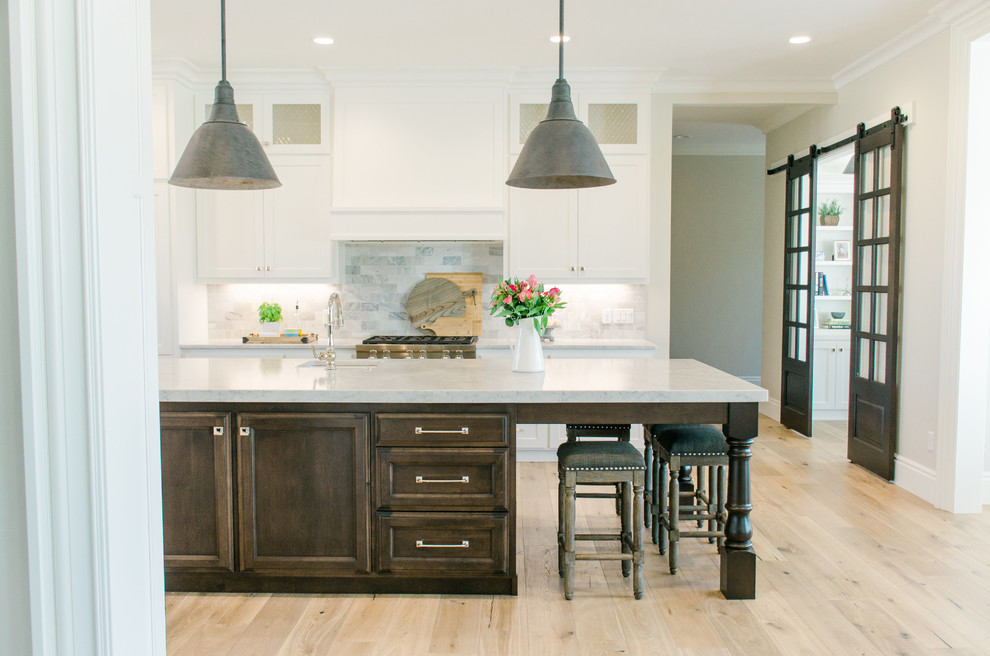 This is an example of a contemporary kitchen in Salt Lake City with light hardwood flooring and an island.