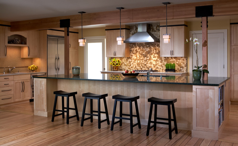 На фото: кухня в современном стиле с светлыми деревянными фасадами, коричневым фартуком, фартуком из плитки мозаики, техникой из нержавеющей стали и барной стойкой