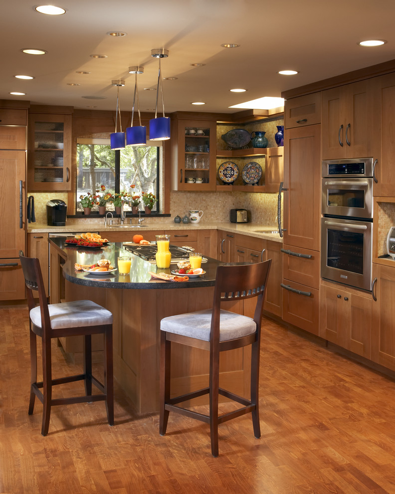Diseño de cocina clásica con electrodomésticos con paneles, armarios estilo shaker, puertas de armario de madera oscura y barras de cocina