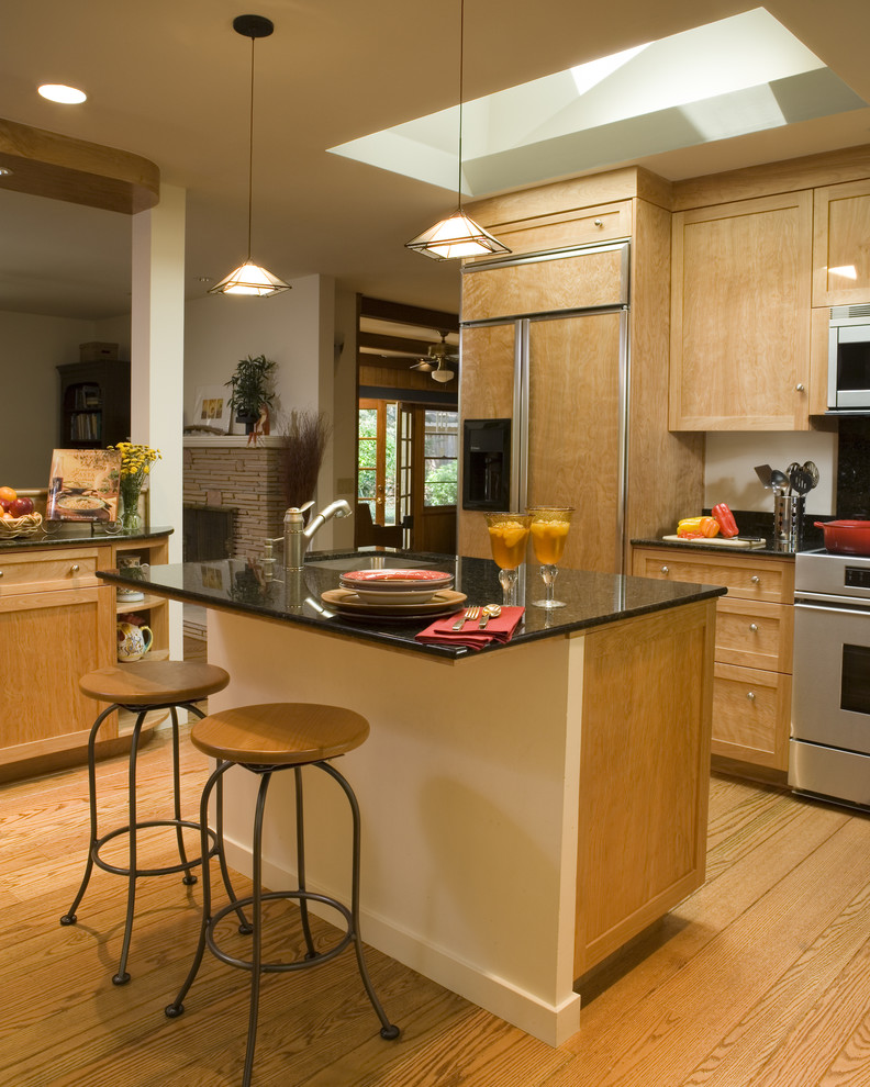 Imagen de cocina actual de roble con armarios estilo shaker, puertas de armario de madera oscura y electrodomésticos con paneles