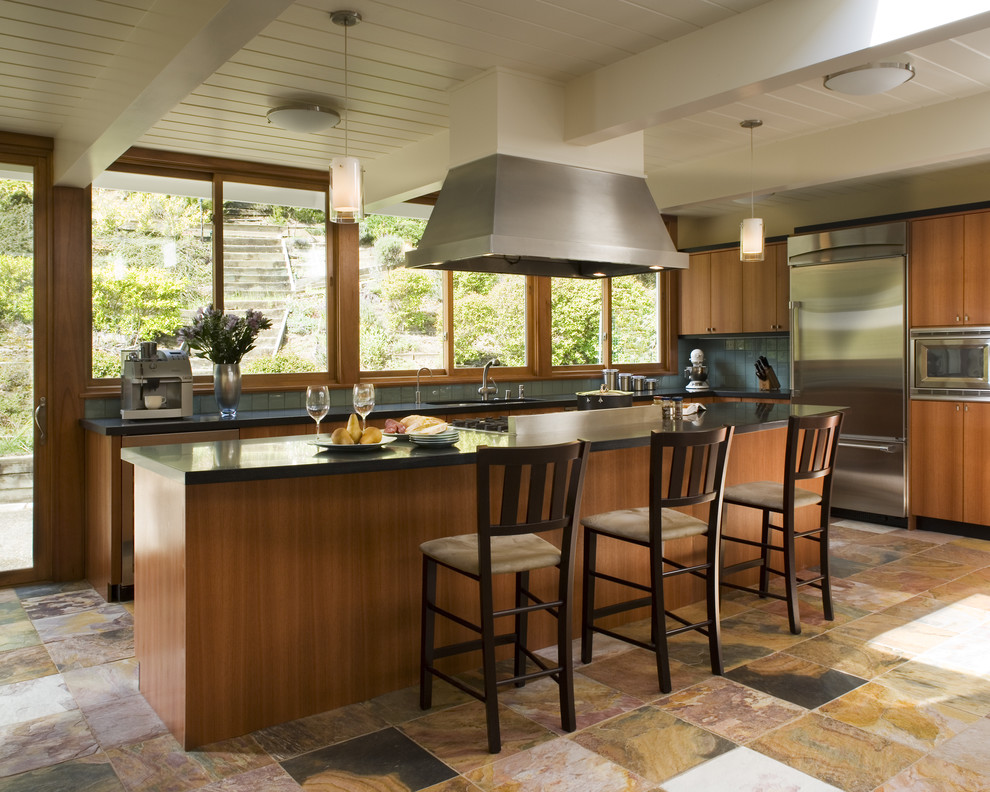 Trendy multicolored floor kitchen photo in San Francisco with flat-panel cabinets, medium tone wood cabinets, blue backsplash and stainless steel appliances