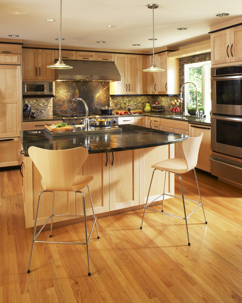 Example of a trendy l-shaped kitchen design in San Francisco with shaker cabinets, light wood cabinets, stainless steel appliances, granite countertops and slate backsplash