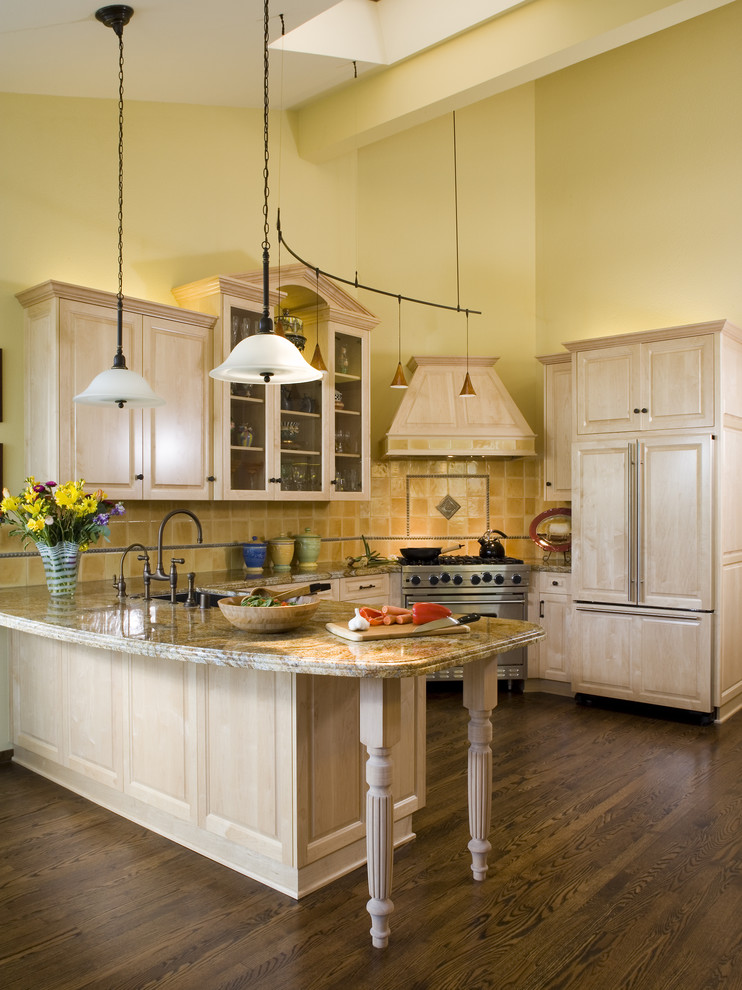 Пример оригинального дизайна: кухня в классическом стиле с фасадами с выступающей филенкой, светлыми деревянными фасадами, желтым фартуком, техникой под мебельный фасад, паркетным полом среднего тона и коричневым полом