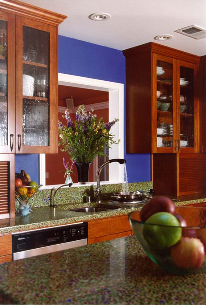 Photo of a traditional kitchen in San Francisco with glass-front cabinets, dark wood cabinets and recycled glass countertops.