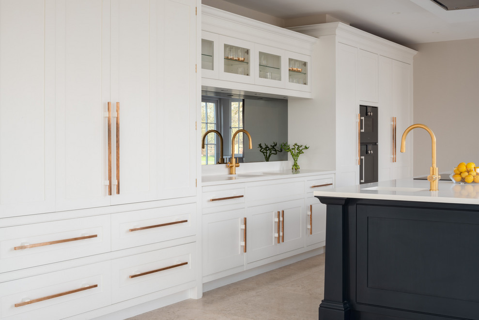 Inspiration for a large contemporary open plan kitchen in London with an integrated sink, shaker cabinets, blue cabinets, composite countertops, black splashback, glass sheet splashback, black appliances, limestone flooring, an island, white floors and white worktops.