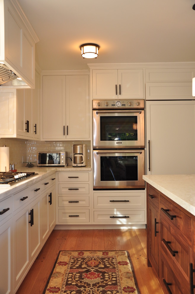 Moderne Küche mit Elektrogeräten mit Frontblende, Schrankfronten mit vertiefter Füllung, weißen Schränken, Marmor-Arbeitsplatte, Küchenrückwand in Weiß und Rückwand aus Metrofliesen in San Francisco