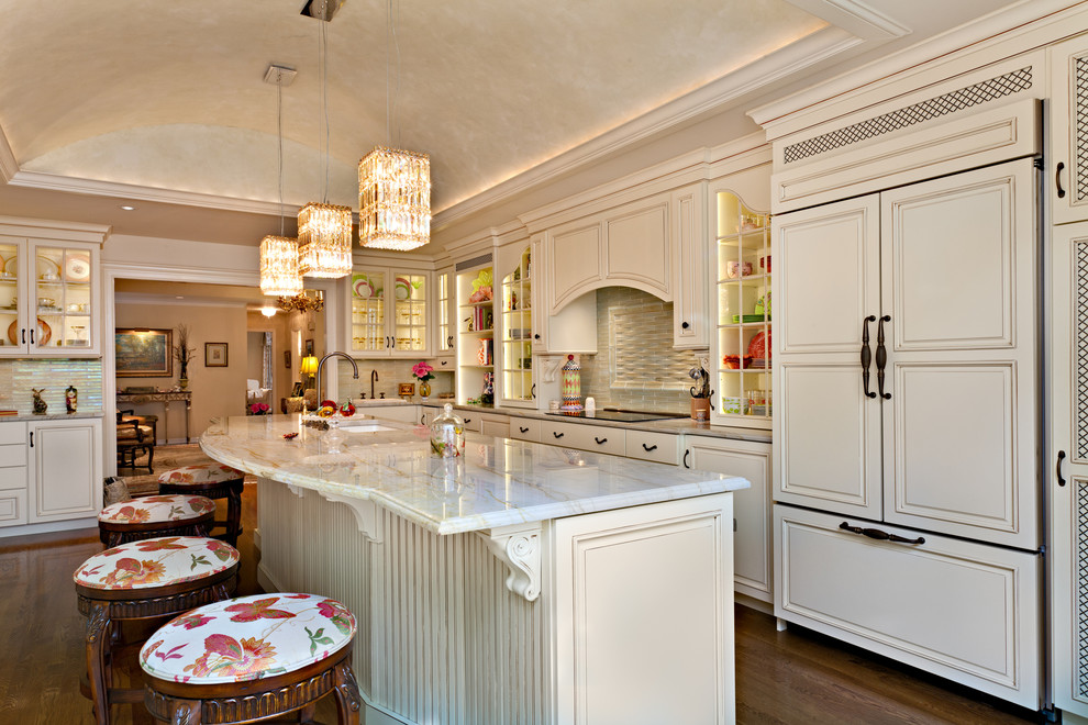 Klassisk inredning av ett stort flerfärgad flerfärgat kök, med en undermonterad diskho, luckor med upphöjd panel, vita skåp, granitbänkskiva, integrerade vitvaror, mellanmörkt trägolv, en köksö och brunt golv