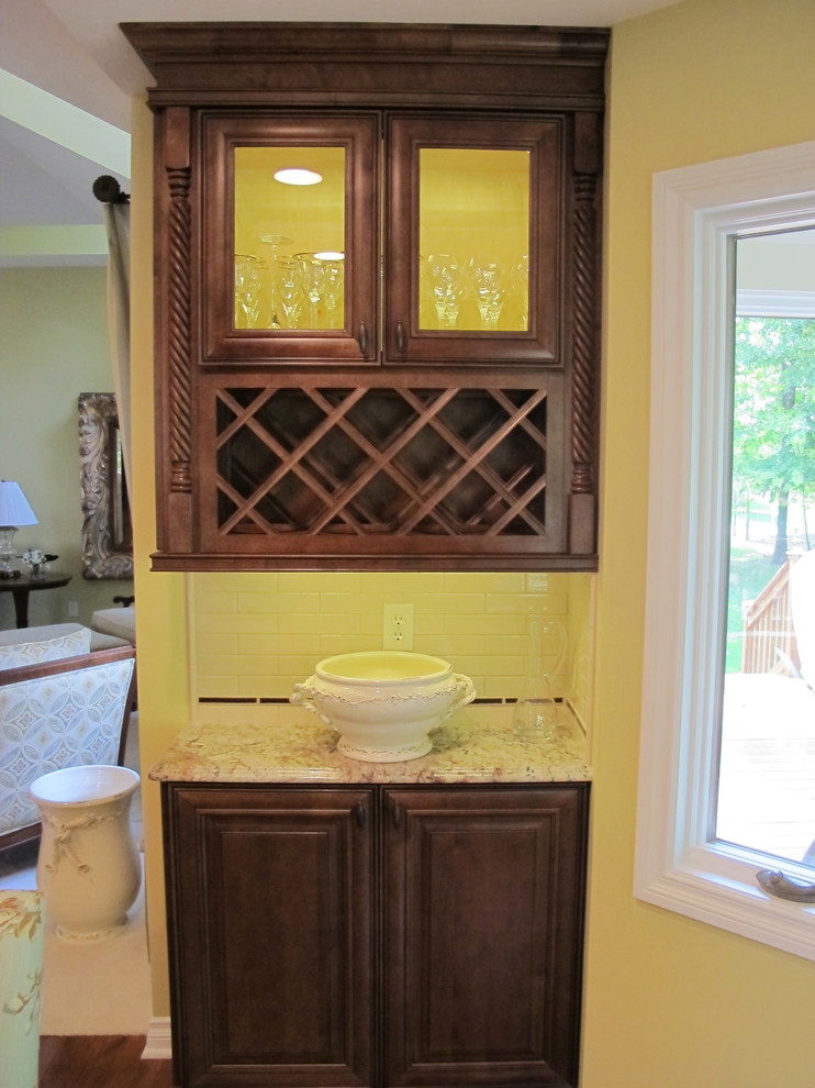 Klassisk inredning av ett kök, med en dubbel diskho, luckor med infälld panel, skåp i mörkt trä, marmorbänkskiva, vitt stänkskydd, rostfria vitvaror, mellanmörkt trägolv och en köksö