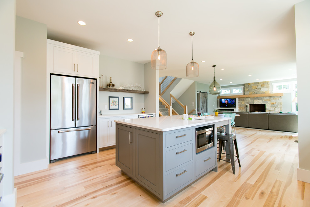 Inspiration for a mid-sized farmhouse u-shaped light wood floor open concept kitchen remodel in Other with a farmhouse sink, recessed-panel cabinets, white cabinets, quartz countertops, white backsplash, ceramic backsplash, stainless steel appliances and an island