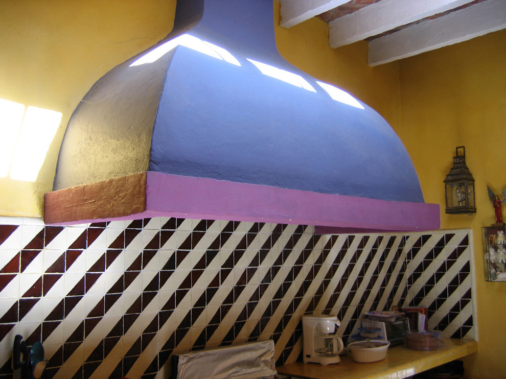 Foto på ett funkis gul kök, med en rustik diskho, öppna hyllor, kaklad bänkskiva, flerfärgad stänkskydd, stänkskydd i keramik, cementgolv och flerfärgat golv