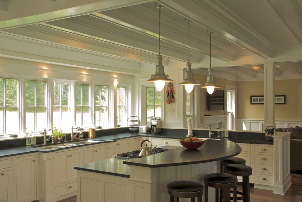This is an example of a large traditional u-shaped open plan kitchen in Other with a triple-bowl sink, beaded cabinets, white cabinets, engineered stone countertops, grey splashback, integrated appliances, dark hardwood flooring and an island.