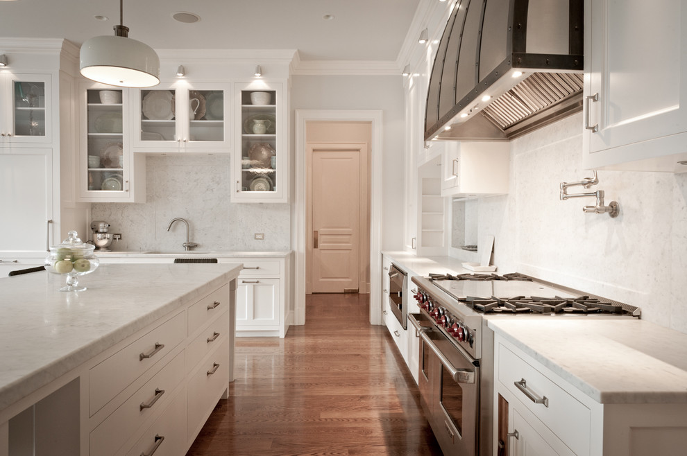 Bild på ett vintage l-kök, med luckor med infälld panel, vita skåp, marmorbänkskiva, vitt stänkskydd, stänkskydd i sten och integrerade vitvaror