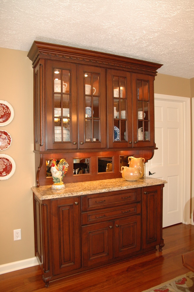 Aménagement d'une cuisine classique en bois foncé avec un placard avec porte à panneau surélevé et un plan de travail en granite.
