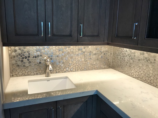 Example of a small tuscan porcelain tile and white floor kitchen design in Miami with an undermount sink, recessed-panel cabinets, dark wood cabinets, limestone countertops, multicolored backsplash, ceramic backsplash, black appliances and an island