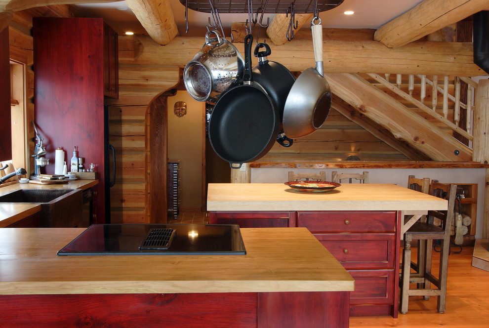 На фото: кухня в стиле рустика с деревянной столешницей и красными фасадами