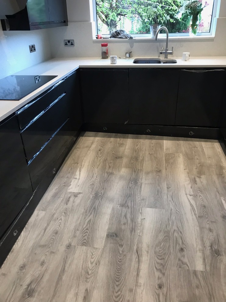 Inspiration for a small contemporary galley gray floor enclosed kitchen remodel in Manchester with an undermount sink, flat-panel cabinets, black cabinets, no island and gray countertops