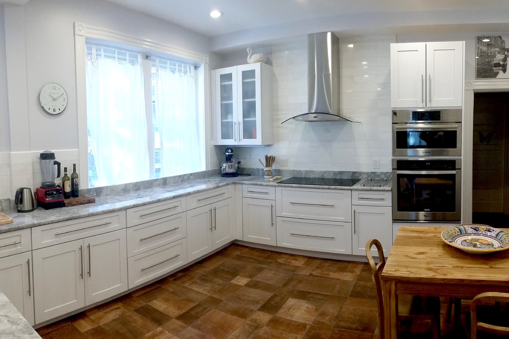 Bild på ett mellanstort funkis u-kök, med en undermonterad diskho, skåp i shakerstil, vita skåp, bänkskiva i kvartsit, vitt stänkskydd, stänkskydd i stenkakel, rostfria vitvaror och klinkergolv i porslin
