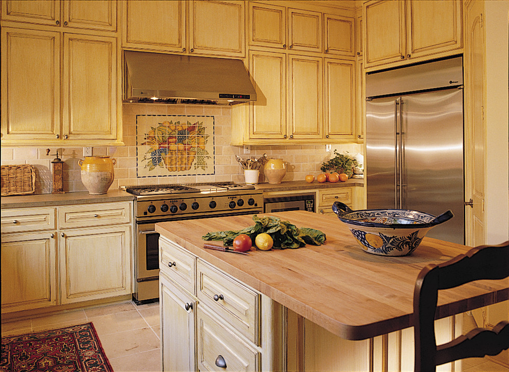 Mittelgroße Klassische Küche in L-Form mit gelben Schränken, Arbeitsplatte aus Holz, bunter Rückwand, Rückwand aus Keramikfliesen, Küchengeräten aus Edelstahl, Keramikboden und Kücheninsel in Houston