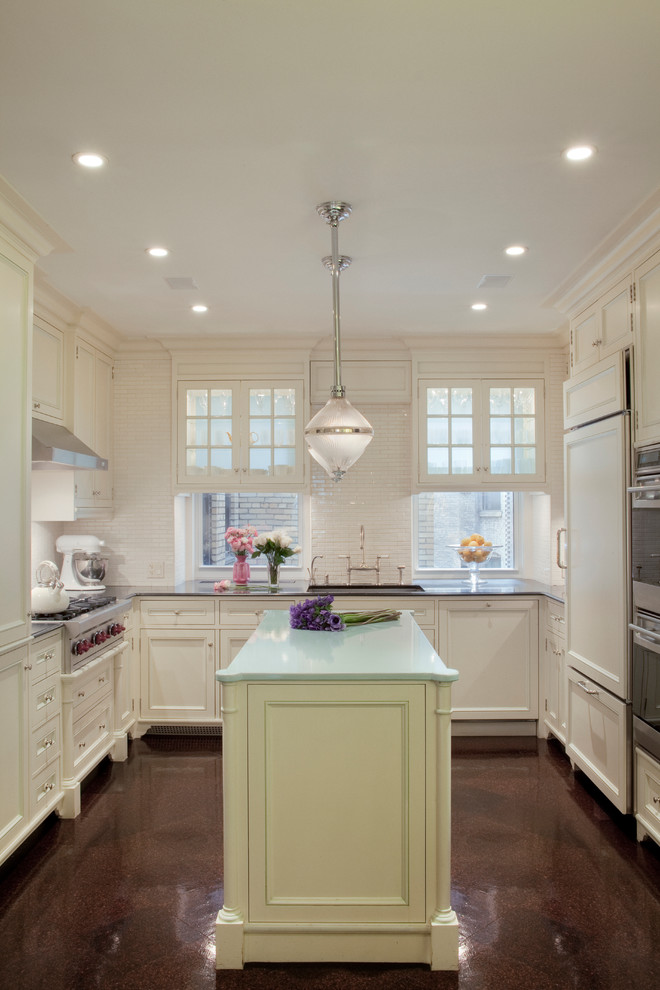 Classic u-shaped enclosed kitchen in New York with white cabinets, white splashback and integrated appliances.