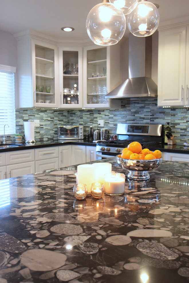 Modern inredning av ett kök, med luckor med glaspanel och rostfria vitvaror