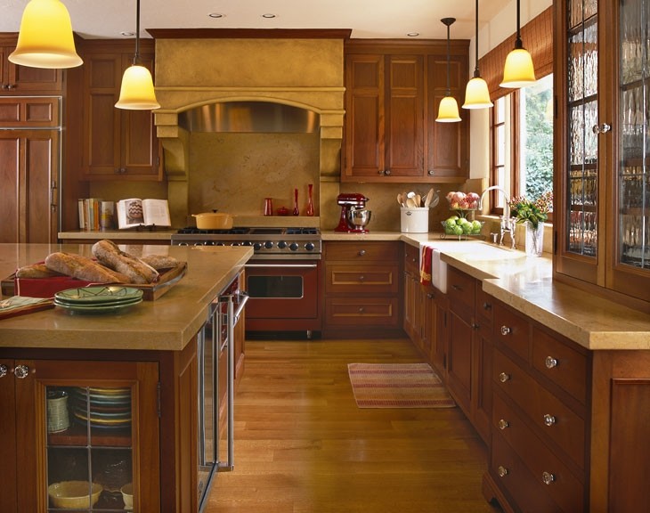 Example of a tuscan l-shaped eat-in kitchen design in San Francisco with a farmhouse sink, dark wood cabinets, limestone countertops, yellow backsplash, colored appliances and stone slab backsplash