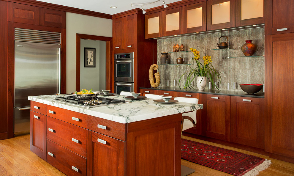 ボストンにある広いトランジショナルスタイルのおしゃれなアイランドキッチン (落し込みパネル扉のキャビネット、中間色木目調キャビネット、シルバーの調理設備、淡色無垢フローリング) の写真