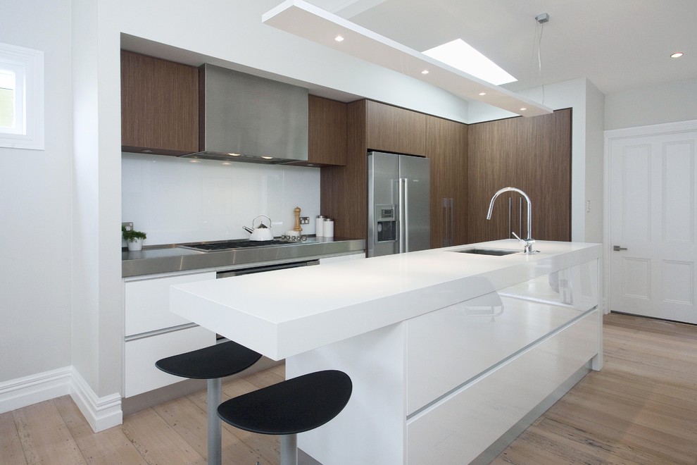 Moderne Küche mit flächenbündigen Schrankfronten, Küchenrückwand in Weiß und Küchengeräten aus Edelstahl in Auckland