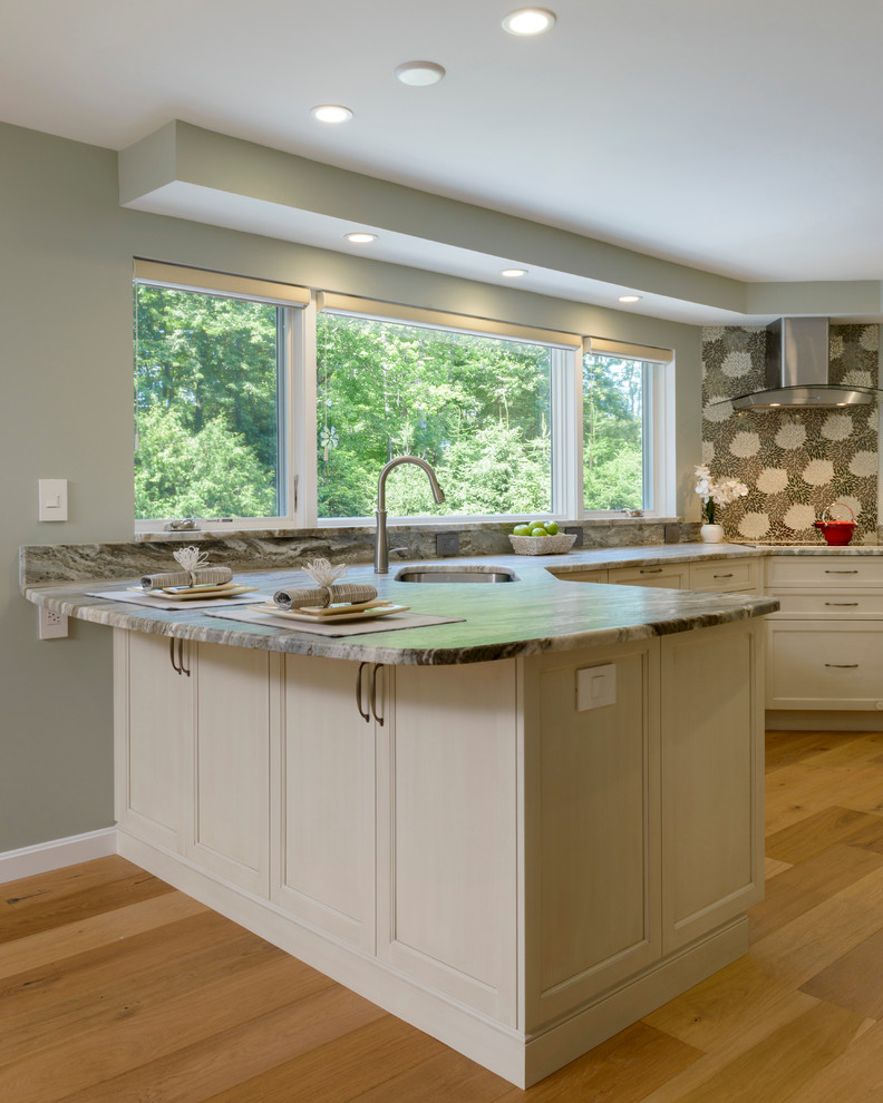 Medium sized traditional l-shaped kitchen/diner in Boston with a double-bowl sink, shaker cabinets, white cabinets, quartz worktops, grey splashback, mosaic tiled splashback, stainless steel appliances, light hardwood flooring and a breakfast bar.