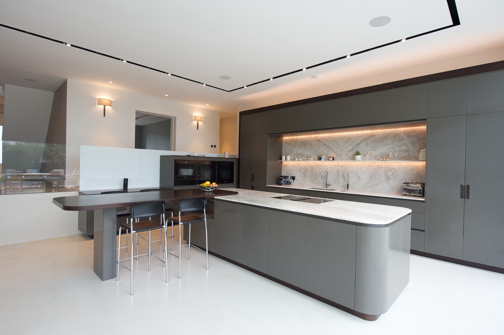 Design ideas for an expansive contemporary l-shaped kitchen in Surrey with flat-panel cabinets, granite worktops, black appliances, concrete flooring, an island, a submerged sink, grey cabinets, white splashback, white floors and white worktops.