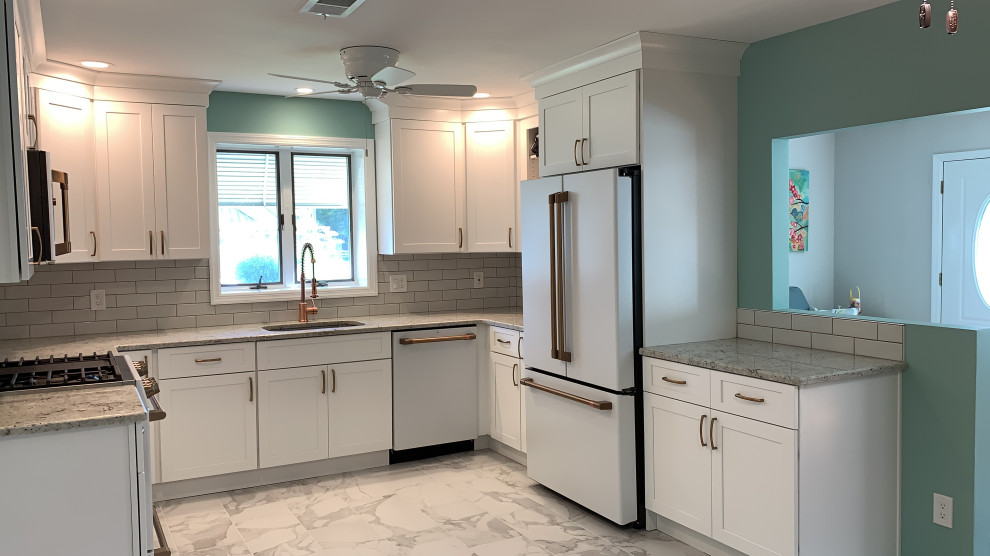 Kitchen - large modern u-shaped porcelain tile and white floor kitchen idea in New York with an undermount sink, shaker cabinets, yellow cabinets, quartzite countertops, white backsplash, ceramic backsplash, white appliances, no island and gray countertops