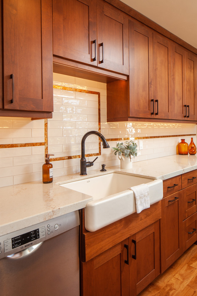 Exempel på ett mellanstort 50 tals vit vitt kök, med en rustik diskho, skåp i shakerstil, bruna skåp, bänkskiva i kvarts, vitt stänkskydd, stänkskydd i keramik, rostfria vitvaror, mellanmörkt trägolv, en köksö och brunt golv