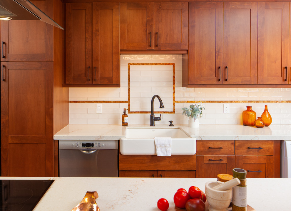 Retro inredning av ett mellanstort vit vitt kök, med en rustik diskho, skåp i shakerstil, bruna skåp, bänkskiva i kvarts, vitt stänkskydd, stänkskydd i keramik, rostfria vitvaror, mellanmörkt trägolv, en köksö och brunt golv
