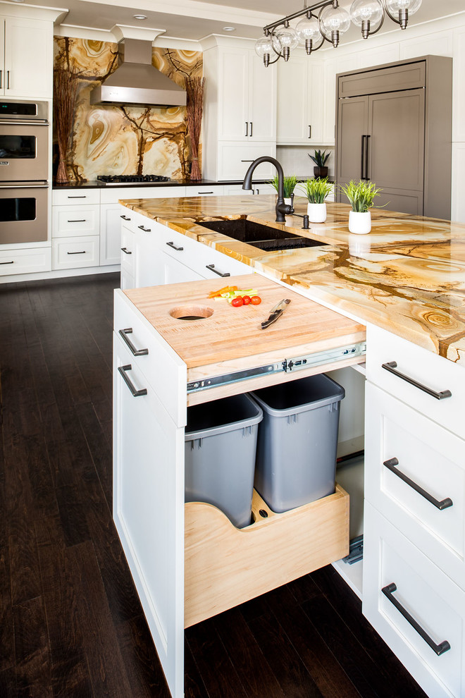 Kitchen - large transitional l-shaped dark wood floor kitchen idea in New York with an undermount sink, shaker cabinets, white cabinets, granite countertops, multicolored backsplash, stone slab backsplash, paneled appliances and an island