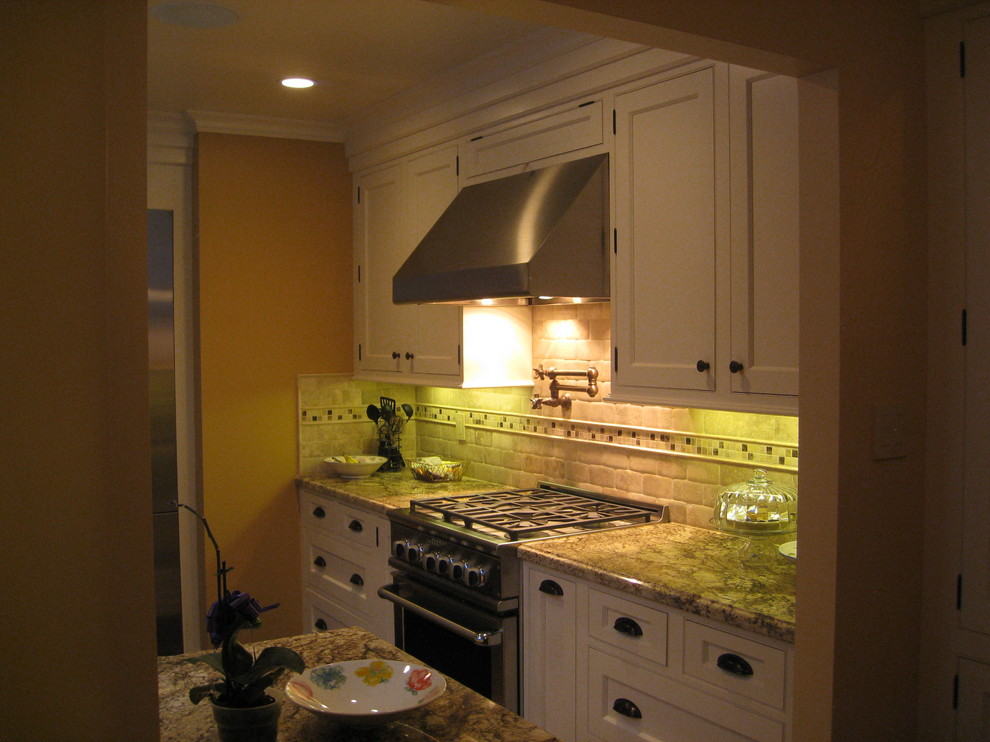 Foto på ett mellanstort vintage kök, med en undermonterad diskho, skåp i shakerstil, vita skåp, granitbänkskiva, flerfärgad stänkskydd, stänkskydd i tunnelbanekakel, rostfria vitvaror och mellanmörkt trägolv