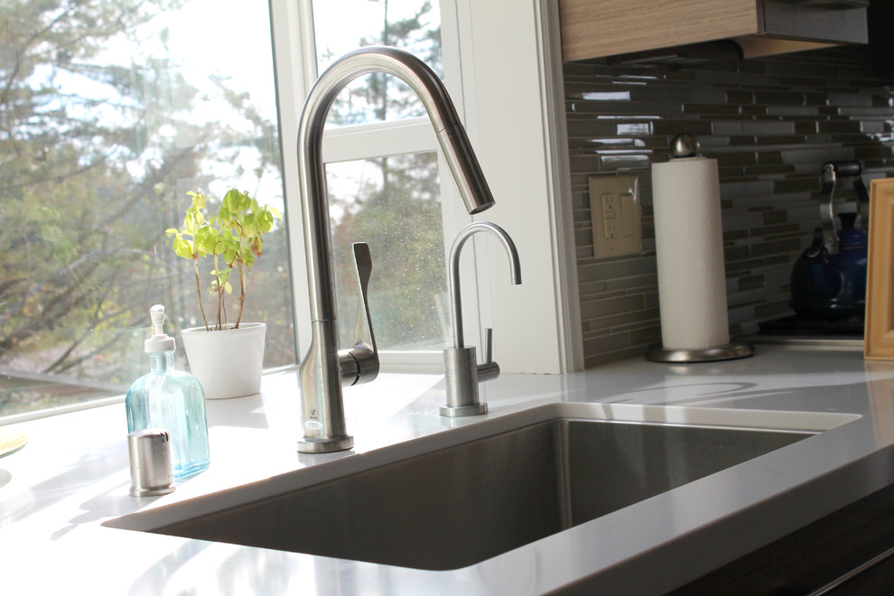Esempio di una cucina minimalista con lavello sottopiano, ante lisce, ante in legno scuro, top in marmo, paraspruzzi verde, paraspruzzi con piastrelle di vetro e elettrodomestici in acciaio inossidabile