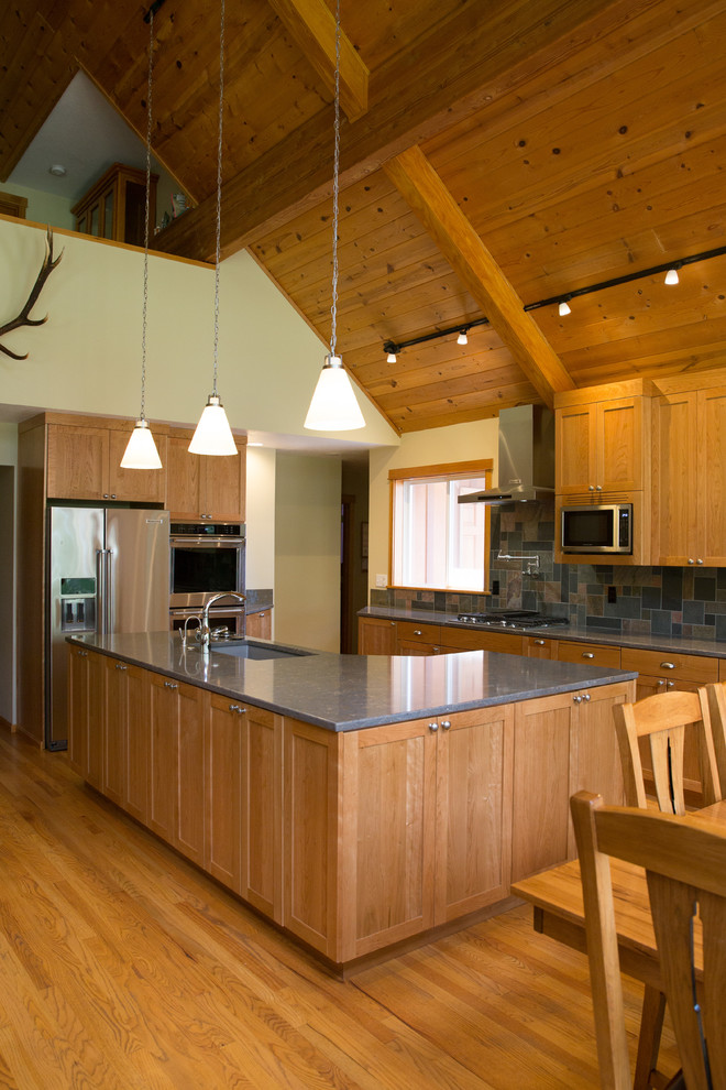 Exempel på ett stort amerikanskt kök, med en undermonterad diskho, skåp i shakerstil, skåp i mellenmörkt trä, bänkskiva i kvarts, flerfärgad stänkskydd, stänkskydd i skiffer, rostfria vitvaror, mellanmörkt trägolv, en köksö och flerfärgat golv