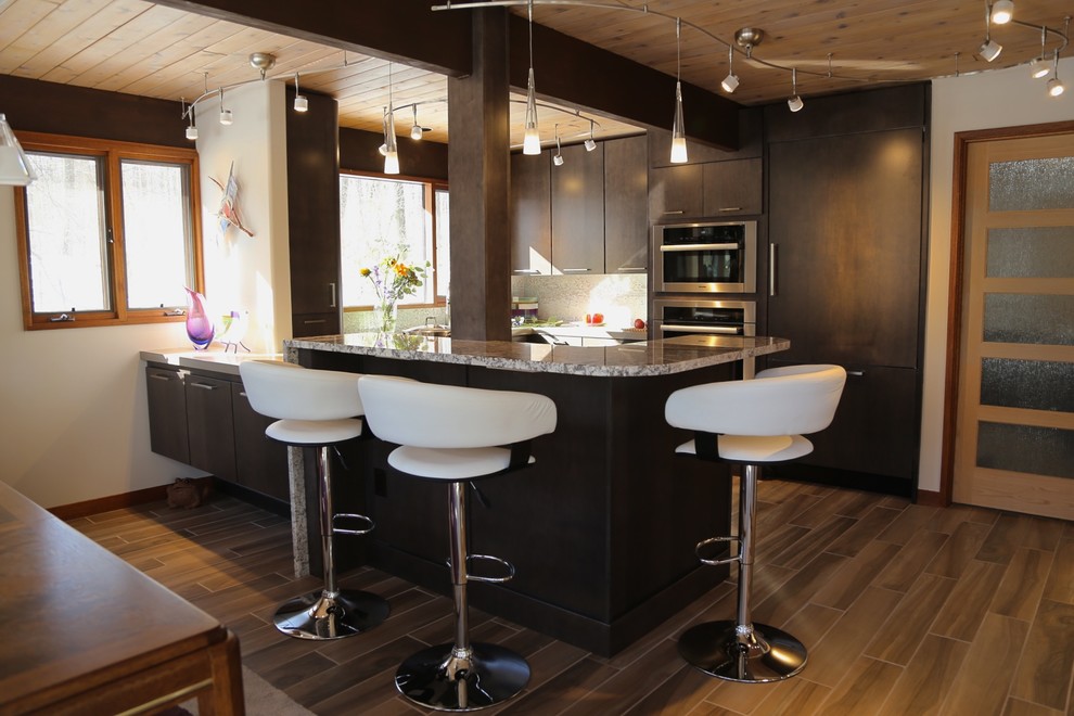 Diseño de cocina contemporánea pequeña con puertas de armario de madera en tonos medios, salpicadero verde, electrodomésticos de acero inoxidable, suelo de madera en tonos medios y península