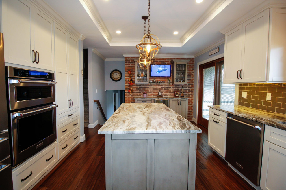 Bild på ett stort funkis flerfärgad flerfärgat kök, med en undermonterad diskho, luckor med infälld panel, skåp i slitet trä, granitbänkskiva, grönt stänkskydd, stänkskydd i porslinskakel, rostfria vitvaror, bambugolv, en köksö och brunt golv