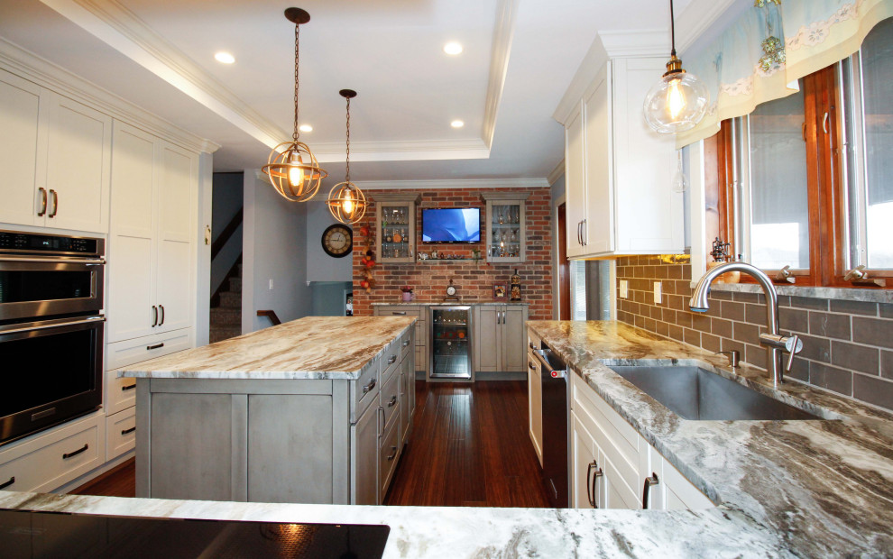 Inredning av ett modernt stort flerfärgad flerfärgat kök, med en undermonterad diskho, luckor med infälld panel, skåp i slitet trä, granitbänkskiva, grönt stänkskydd, stänkskydd i porslinskakel, rostfria vitvaror, bambugolv, en köksö och brunt golv