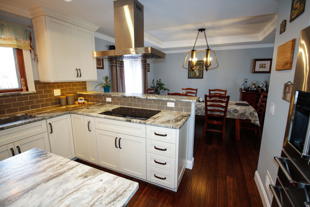 Modern inredning av ett stort flerfärgad flerfärgat kök, med en undermonterad diskho, luckor med infälld panel, skåp i slitet trä, granitbänkskiva, grönt stänkskydd, stänkskydd i porslinskakel, rostfria vitvaror, bambugolv, en köksö och brunt golv