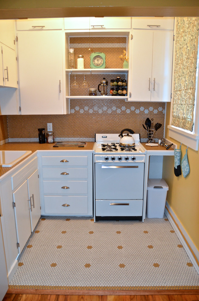 Modelo de cocinas en L rústica pequeña cerrada con puertas de armario blancas, salpicadero amarillo y salpicadero de azulejos de porcelana