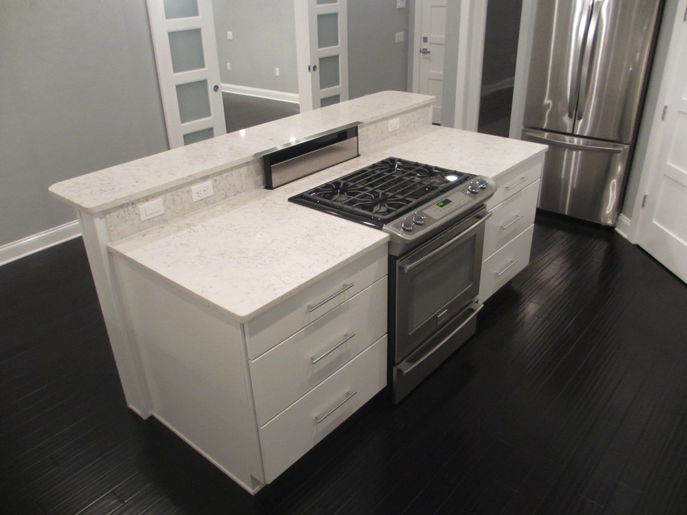 Example of a mid-sized u-shaped bamboo floor open concept kitchen design in Miami with an undermount sink, shaker cabinets, white cabinets, quartz countertops, gray backsplash, stainless steel appliances and an island