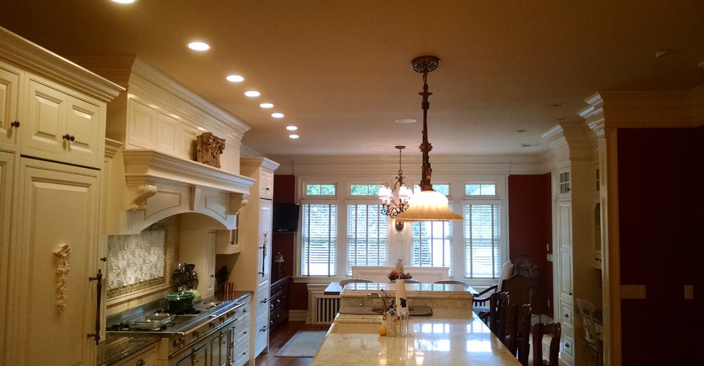 Foto på ett stort lantligt kök, med en rustik diskho, luckor med upphöjd panel, vita skåp, flerfärgad stänkskydd, stänkskydd i tunnelbanekakel, integrerade vitvaror, mörkt trägolv, en köksö, marmorbänkskiva och brunt golv