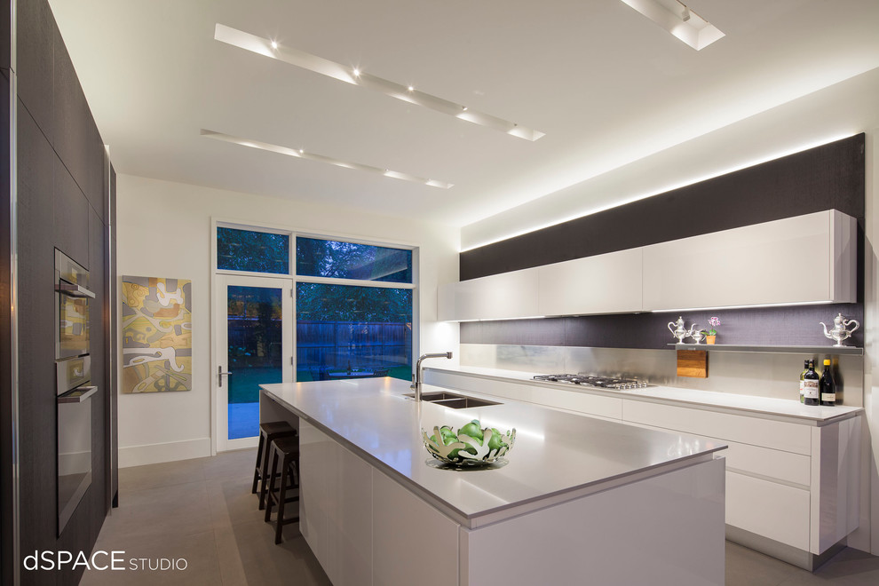 Design ideas for a large contemporary galley enclosed kitchen in Chicago with a double-bowl sink, flat-panel cabinets, white cabinets, metallic splashback, integrated appliances, porcelain flooring, an island and engineered stone countertops.