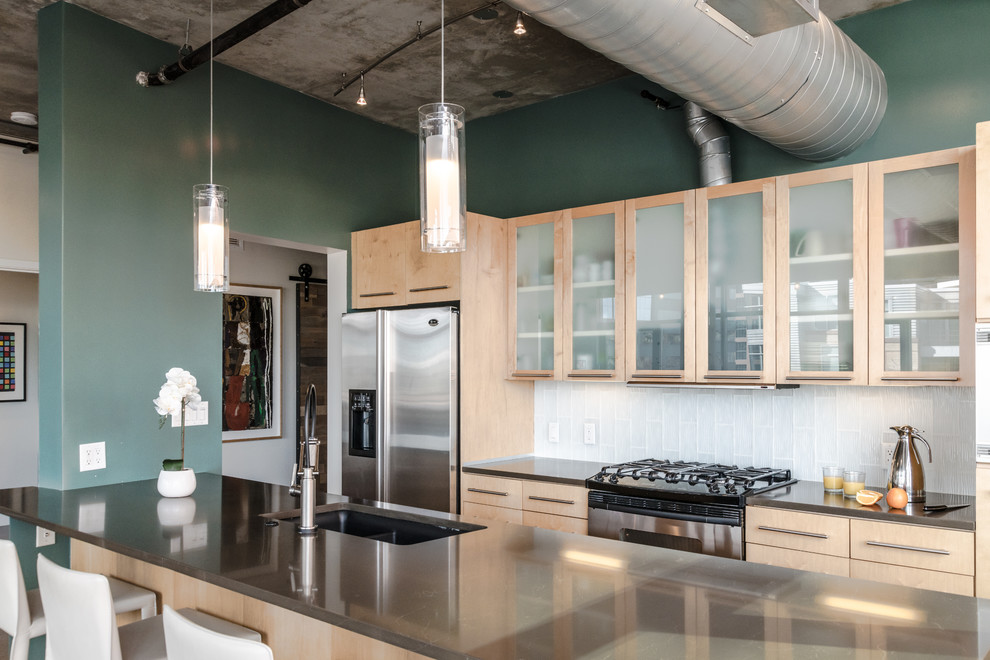 Zweizeilige Industrial Küche mit Unterbauwaschbecken, Glasfronten, hellen Holzschränken, Kücheninsel und grauer Arbeitsplatte in Denver