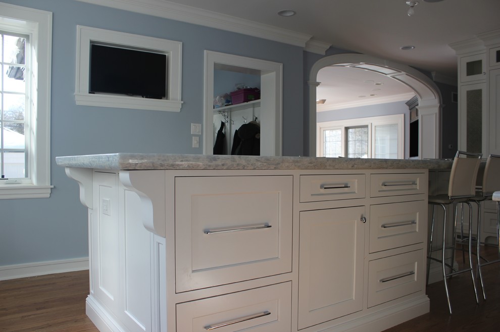 Exempel på ett stort klassiskt blå blått kök, med luckor med infälld panel, vita skåp, bänkskiva i kvartsit, rostfria vitvaror, en undermonterad diskho, blått stänkskydd, mörkt trägolv, en köksö och brunt golv