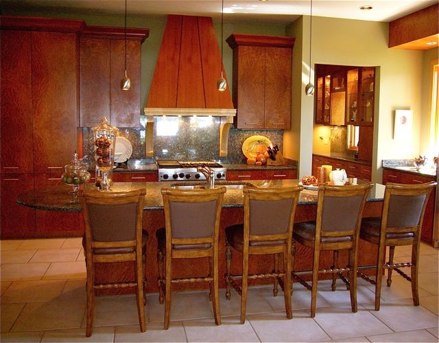 Immagine di una cucina mediterranea con lavello sottopiano, ante lisce, ante rosse, top in granito, paraspruzzi rosso, paraspruzzi in lastra di pietra e elettrodomestici da incasso