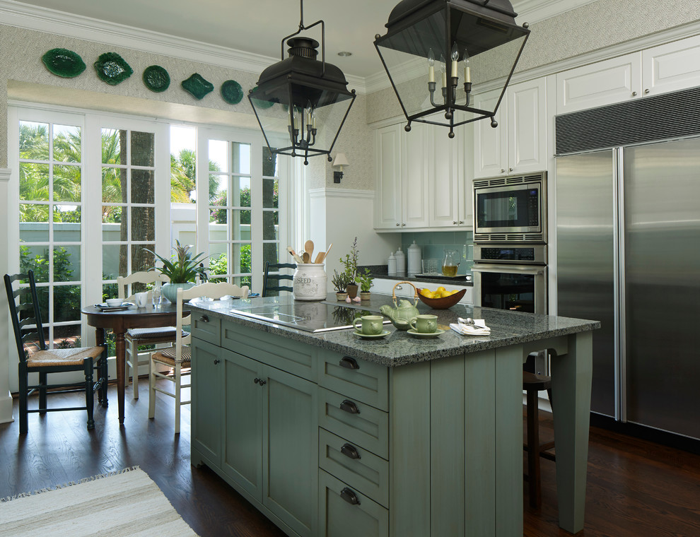 Inspiration for a medium sized traditional l-shaped kitchen/diner in Miami with raised-panel cabinets, white cabinets, blue splashback, stainless steel appliances, dark hardwood flooring, an island and brown floors.